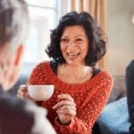 menopause-cafe-woman-laughing-holding-coffee