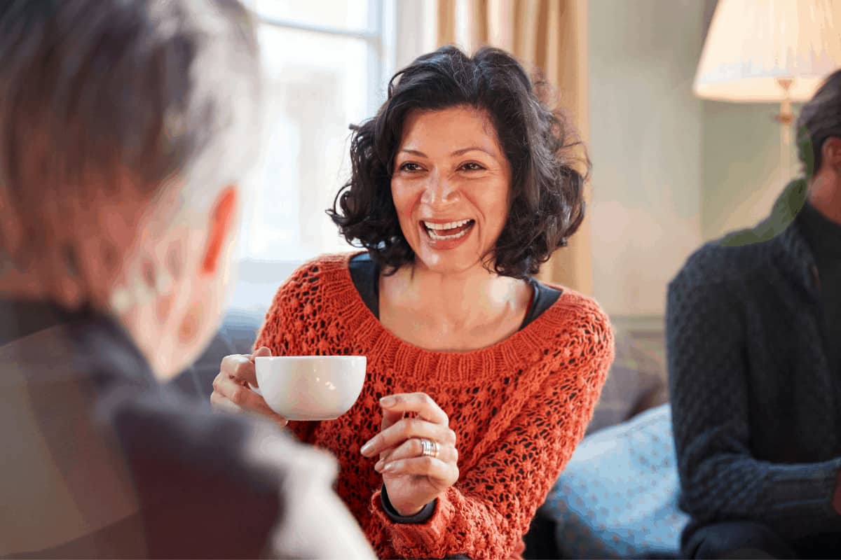 menopause-cafe-woman-laughing-holding-coffee