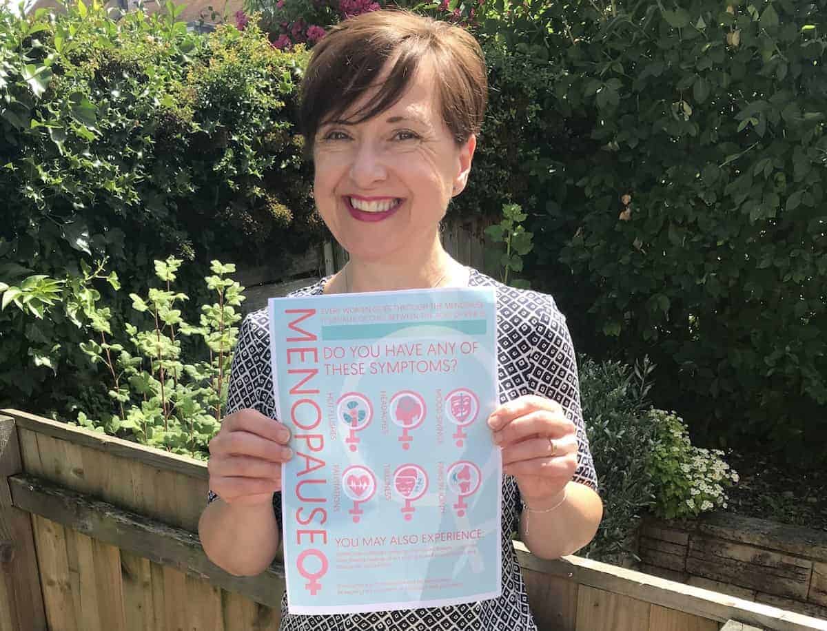 Elizabeth Carr-Ellis holding a KnowYourMenopause poster