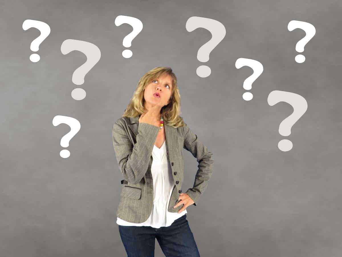 Woman with question marks around her thining about HRT