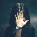 Woman covering her face with rosacea