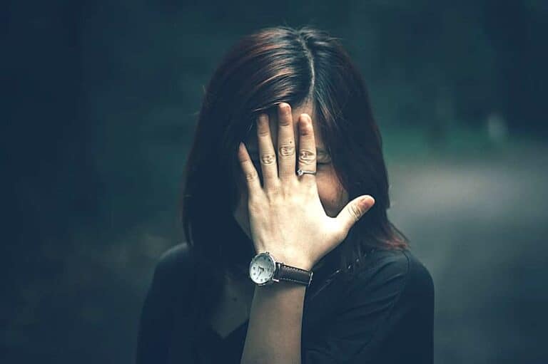 Woman covering her face with rosacea